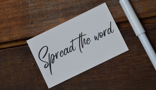 Top view of pen and memo note written with SPREAD THE WORD. Top view of pen and memo note written with SPREAD THE WORD.
